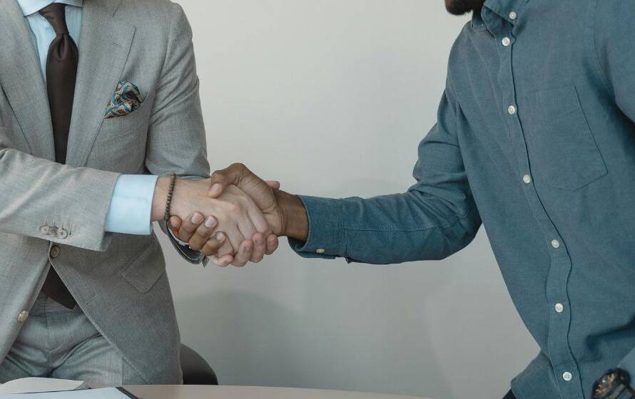 Two professionals shaking hands during a job interview, representing the CBSA hiring process