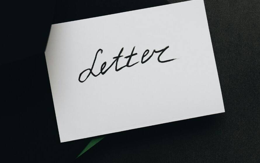 Envelope and cover letter card placed on a desk, symbolizing job applications, professional communication, and recruitment screening processes.