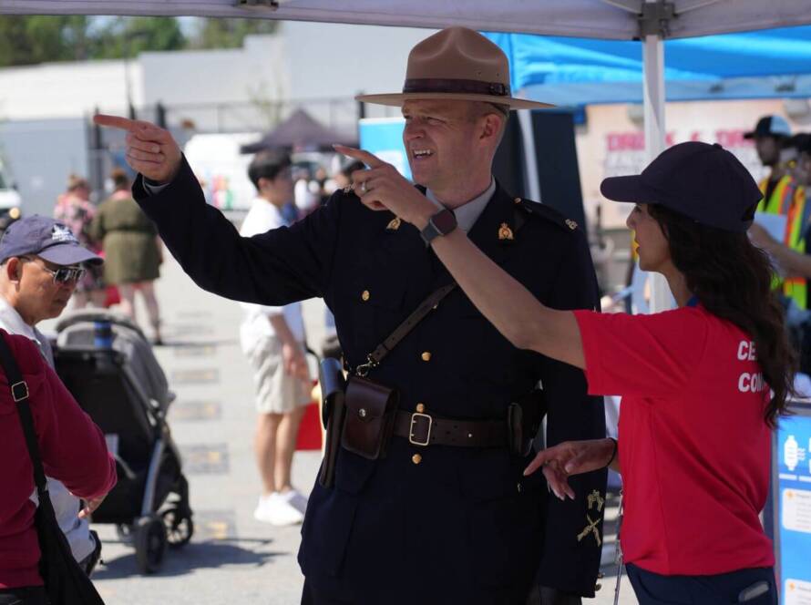 Border services officer speaking with a civilian at a public event, representing CBSA careers, salary, and benefits