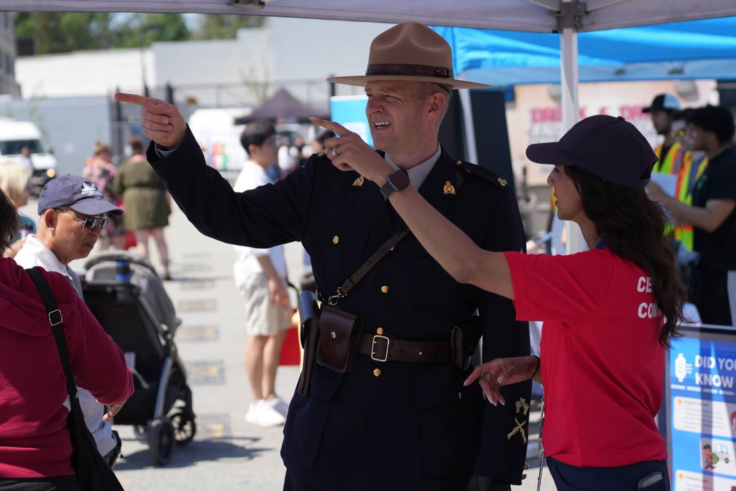 Border services officer speaking with a civilian at a public event, representing CBSA careers, salary, and benefits