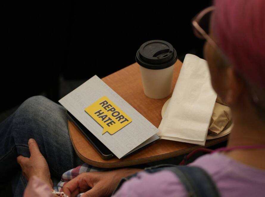 Person reviewing documents with a “report hate” message, representing preparation for CBSA exam and application process