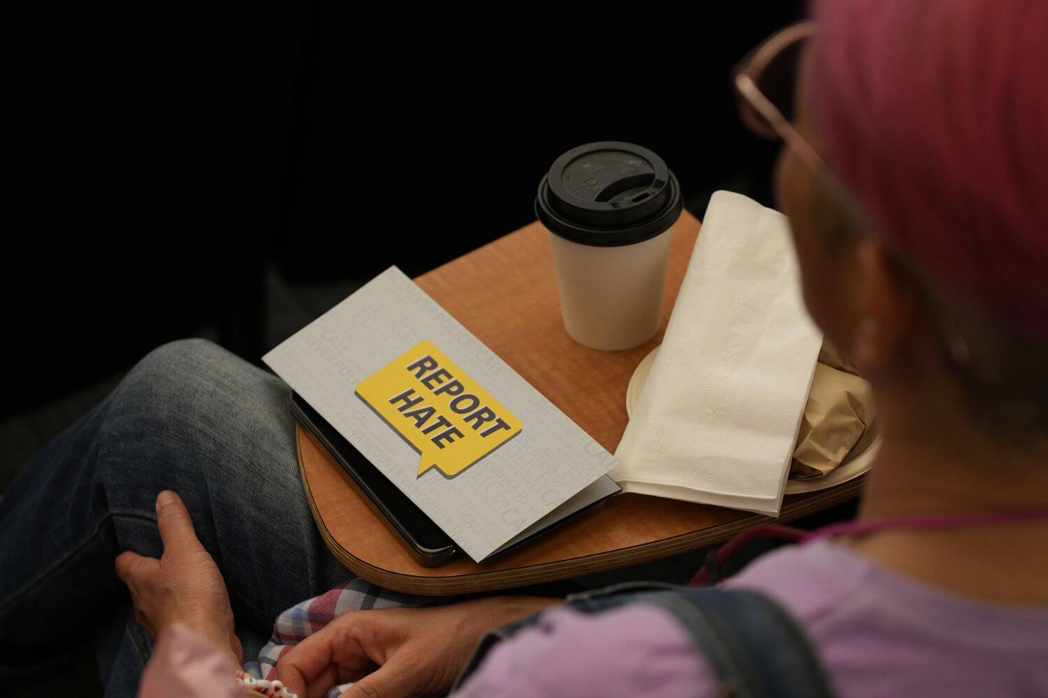 Person reviewing documents with a “report hate” message, representing preparation for CBSA exam and application process