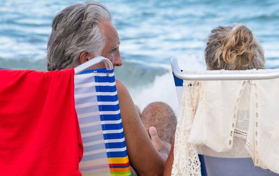 Retired couple relaxing in beach chairs by the ocean, representing retirement planning, pension benefits, and life after a career with the Canada Border Services Agency.