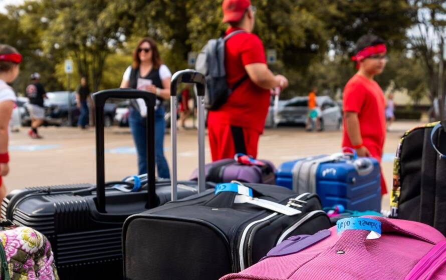 Collection of suitcases and travel bags gathered in an outdoor travel area, with travelers standing nearby, representing international travel, border crossings, immigration processing, and customs enforcement activities.