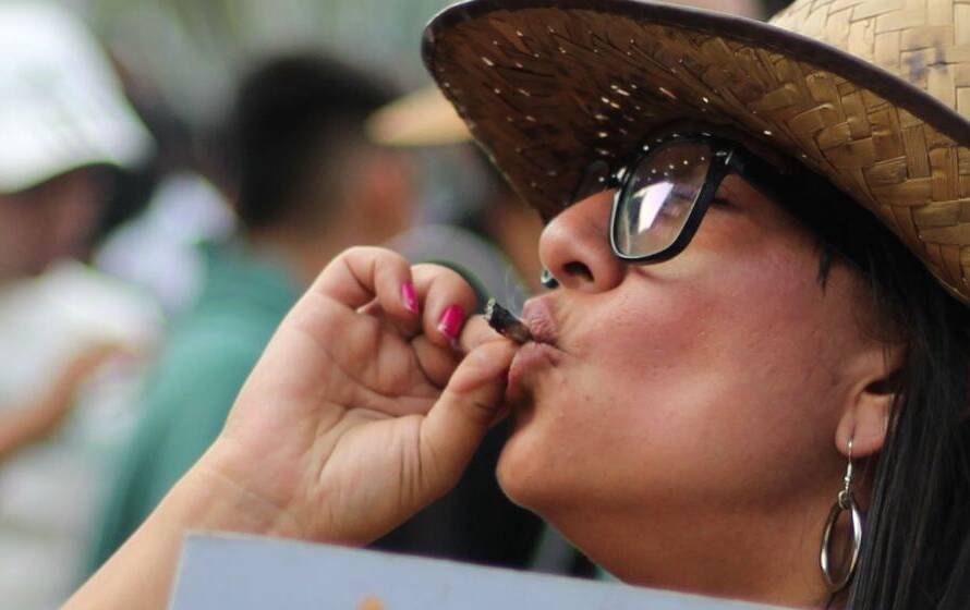 Person wearing a hat and glasses smoking cannabis in a public setting, representing CBSA policies on cannabis use, drug testing, and fitness for duty for Border Services Officers.