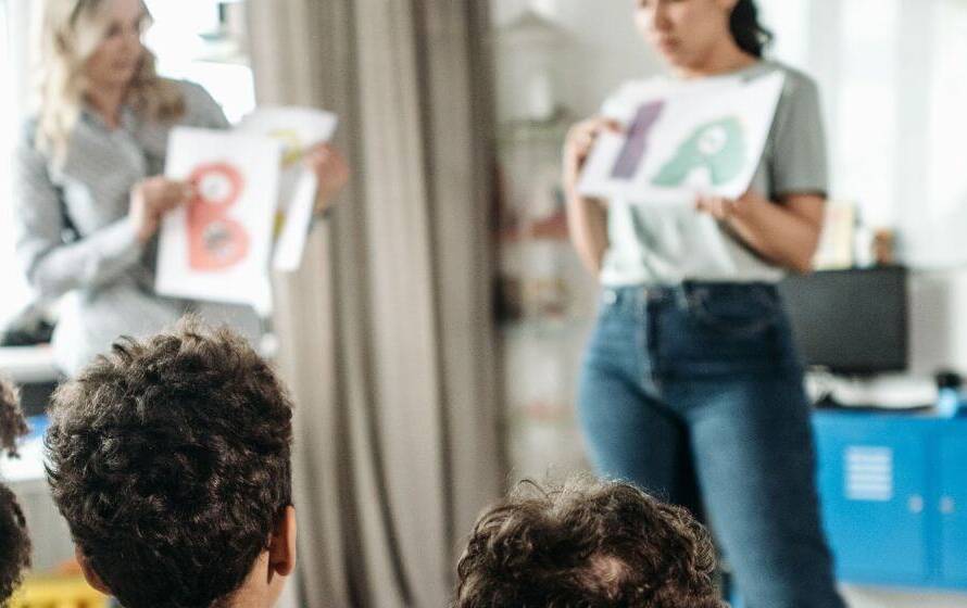 Students attending a classroom lesson with two instructors presenting educational materials, representing the education and qualification requirements for becoming a CBSA Border Services Officer.